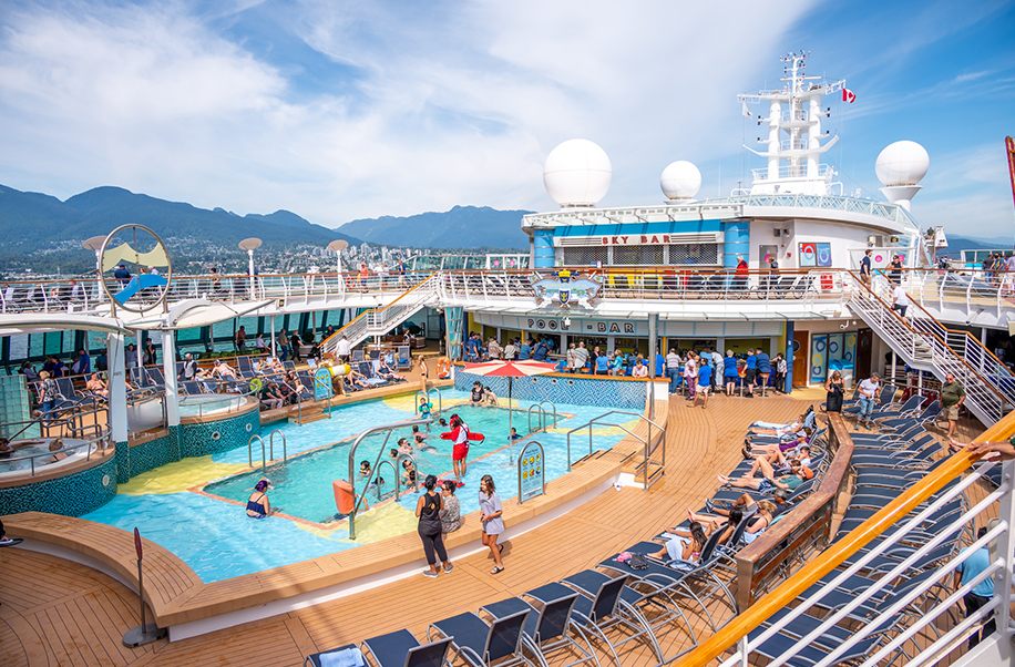 Busy family pool deck on a large cruise ship seen from above